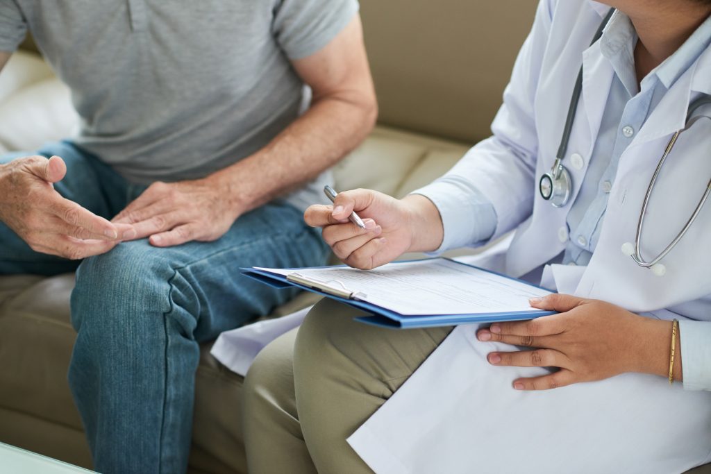 Doctor medical loan on clipboard during home visit - Winz Credit medical loan